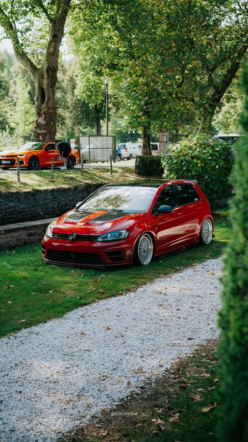 Tiefergelegter roter Volkswagen Golf R in einer Parkanlage